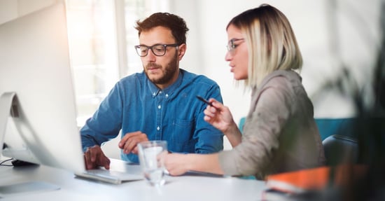 Zwei Personen, die Daten am Computer prüfen 