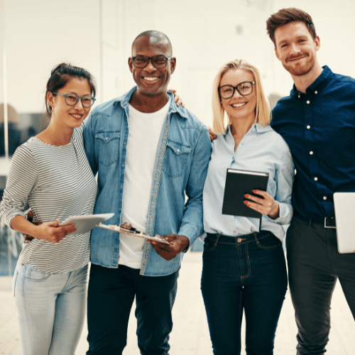 Das Team steht und lächelt mit mobilen Tablet-Geräten