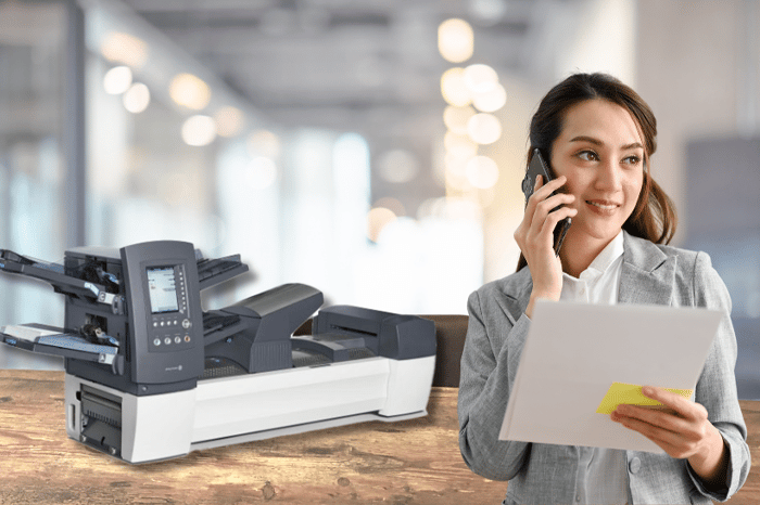 Frau am Telefon vor einer Relaiskuvertiermaschine