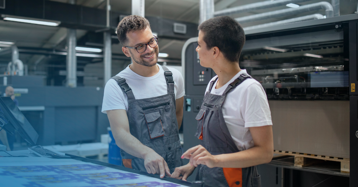 Mitarbeiter einer Druckerei bei der Arbeit mit einem UV-Flachbettdrucker
