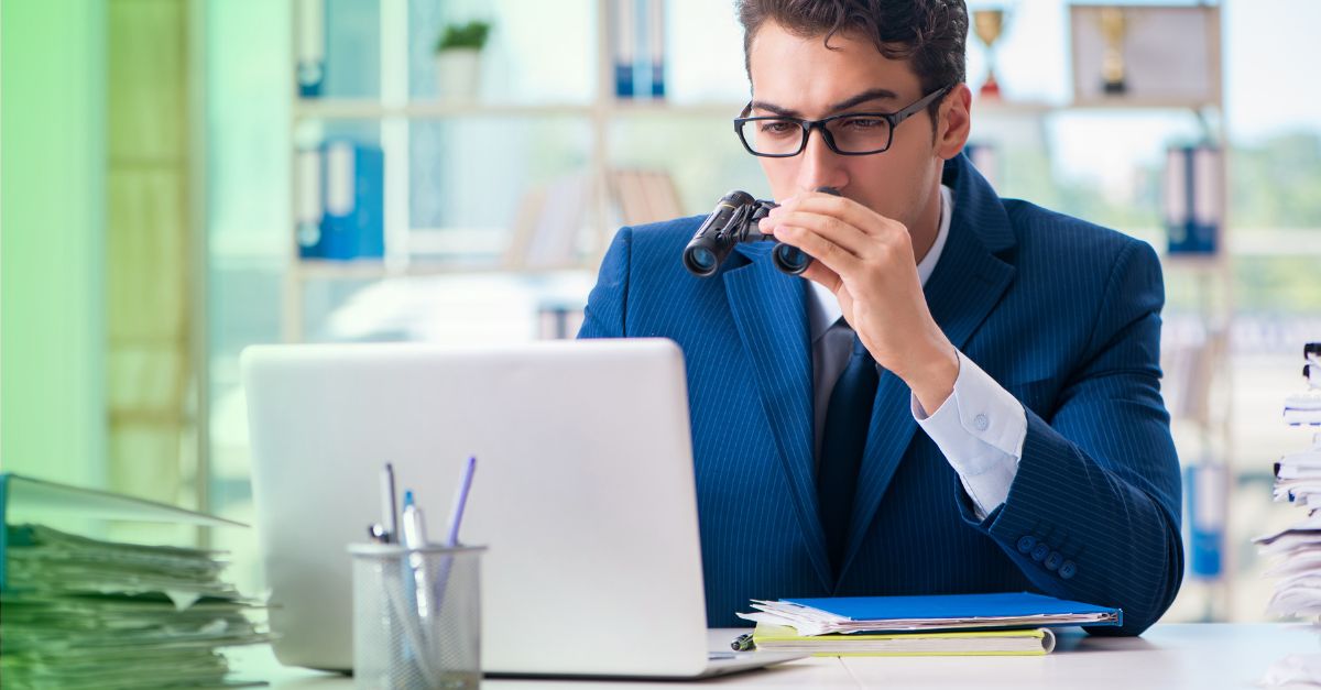 Buchhalter mit Fernglas prüft Betrug am Laptop 